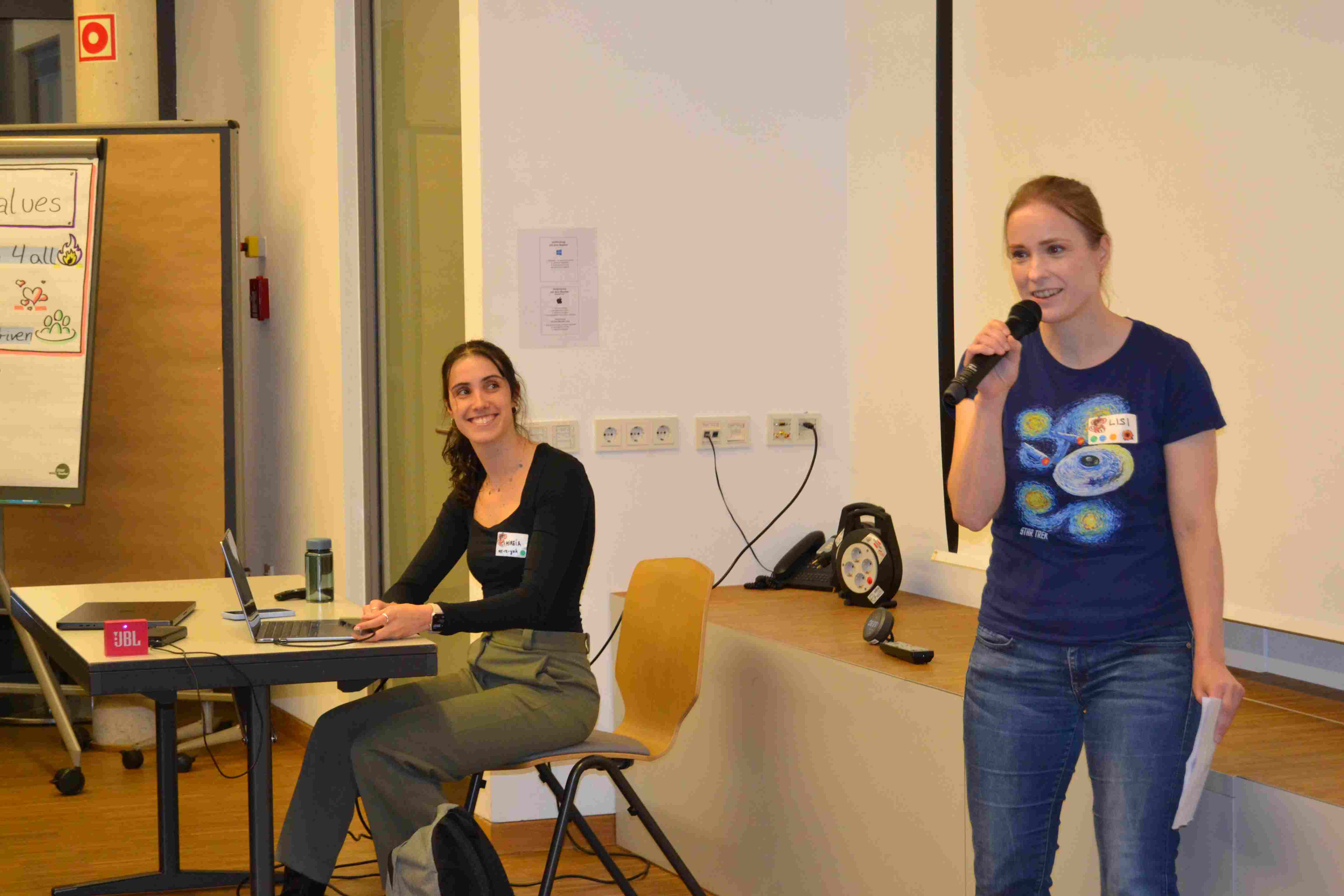 The picture shows the announcement of the keynote of Mireia by one of the organizers with a star trek T-shirt.